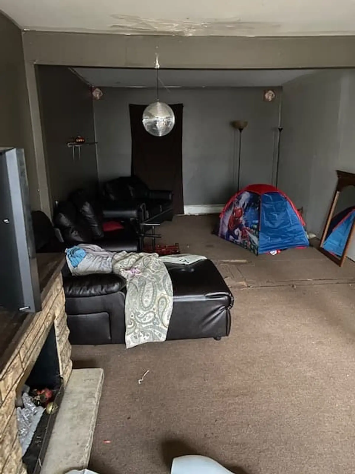 Selling a house after a life change in Middle Island: carpeted den with furniture and toys left out