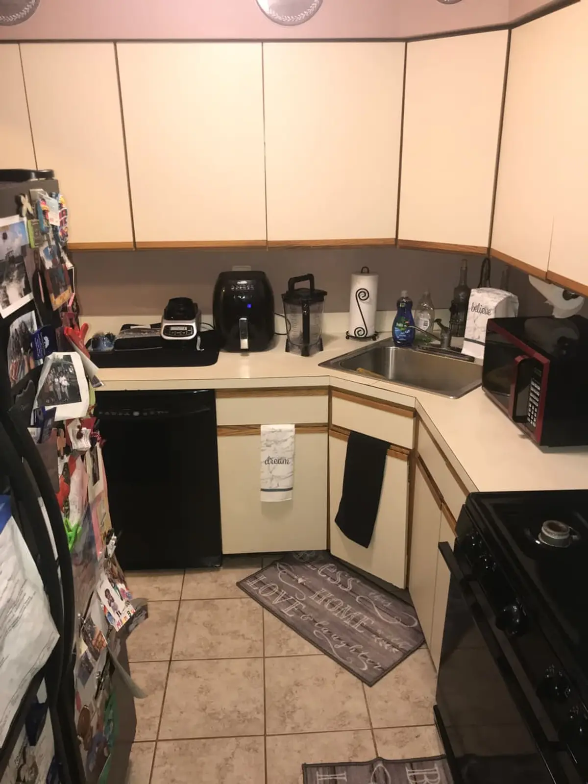 Selling a house with a reverse mortgage in Middle Island: condo kitchen with cream cabinets and a tile floor
